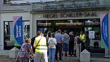 Besuchende warten vor dem Eingang Berliner Platz