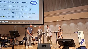 Gäste unterhalten sich auf der Bühne des Schillersaals.