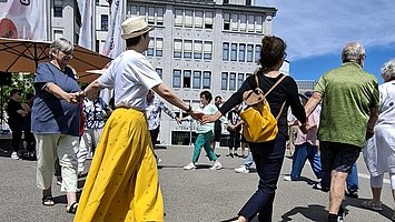 Besuchende tanzen gemeinsam auf dem Berliner Platz