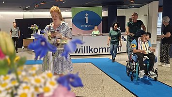 Besuchende vor dem Infopunkt