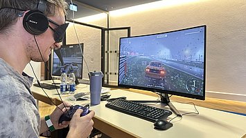 Besucher spielt mit verbundenen Augen ein Computergame